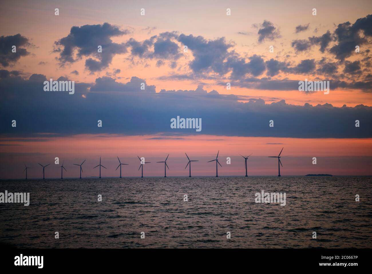 Blick vom Strand Amager auf Windkraftanlagen im Meer bei Sonnenaufgang, Offshore-Windpark, Kopenhagen, Dänemark Stockfoto