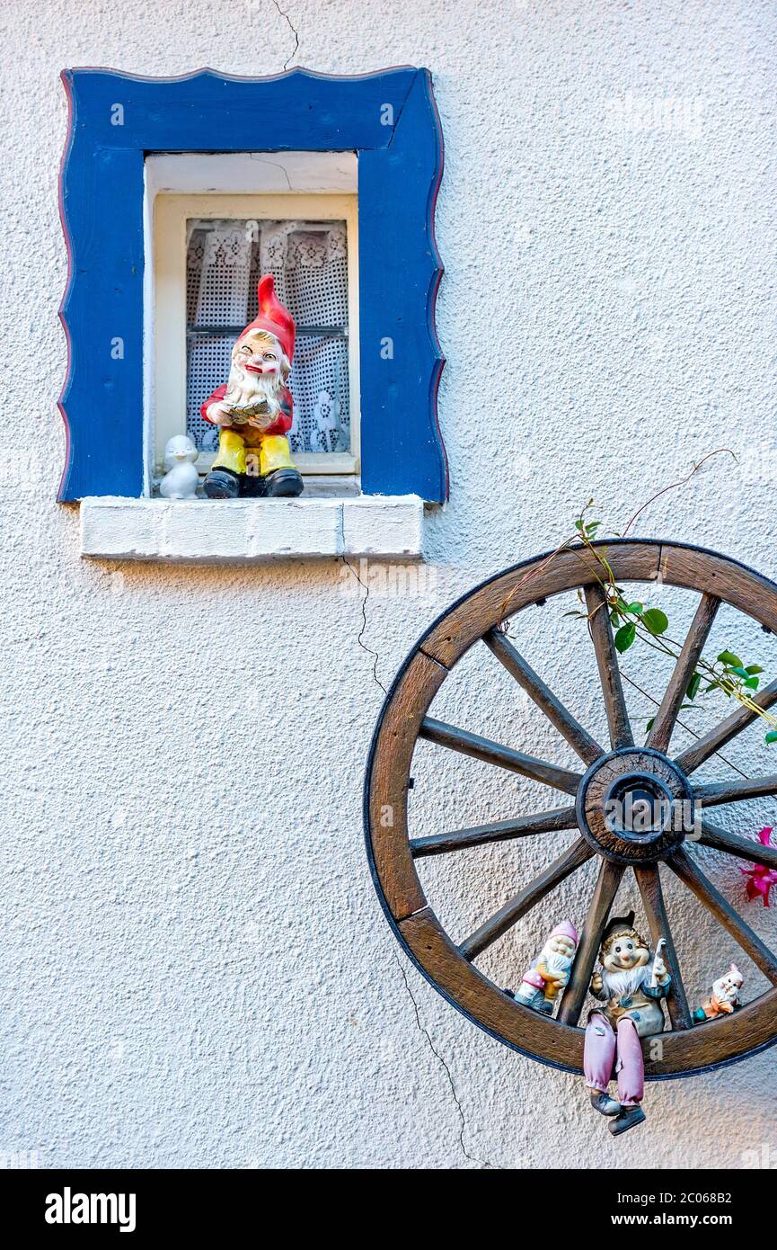 Gartenzwerge an einem kleinen Fenster und in einem hölzernen Wagenrad, Steinau an der Straße, Hessen, Deutschland Stockfoto Gartenzwerge an einem kleinen Fenster und in einem hölzernen Wagenrad, Steinau an der Straße, Hessen, Deutschland Stockfoto