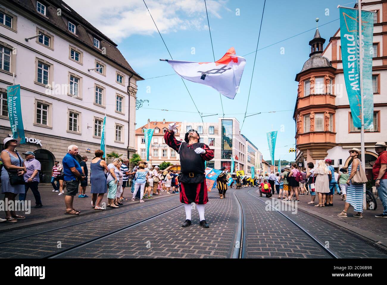 Fahnenschwänger der traditionellen Volksmusik- und Künstlergruppe Trääs aus Sulzbach Murr werfen während der Kiliani-Messe-Parade Fahnen in die Luft. Stockfoto