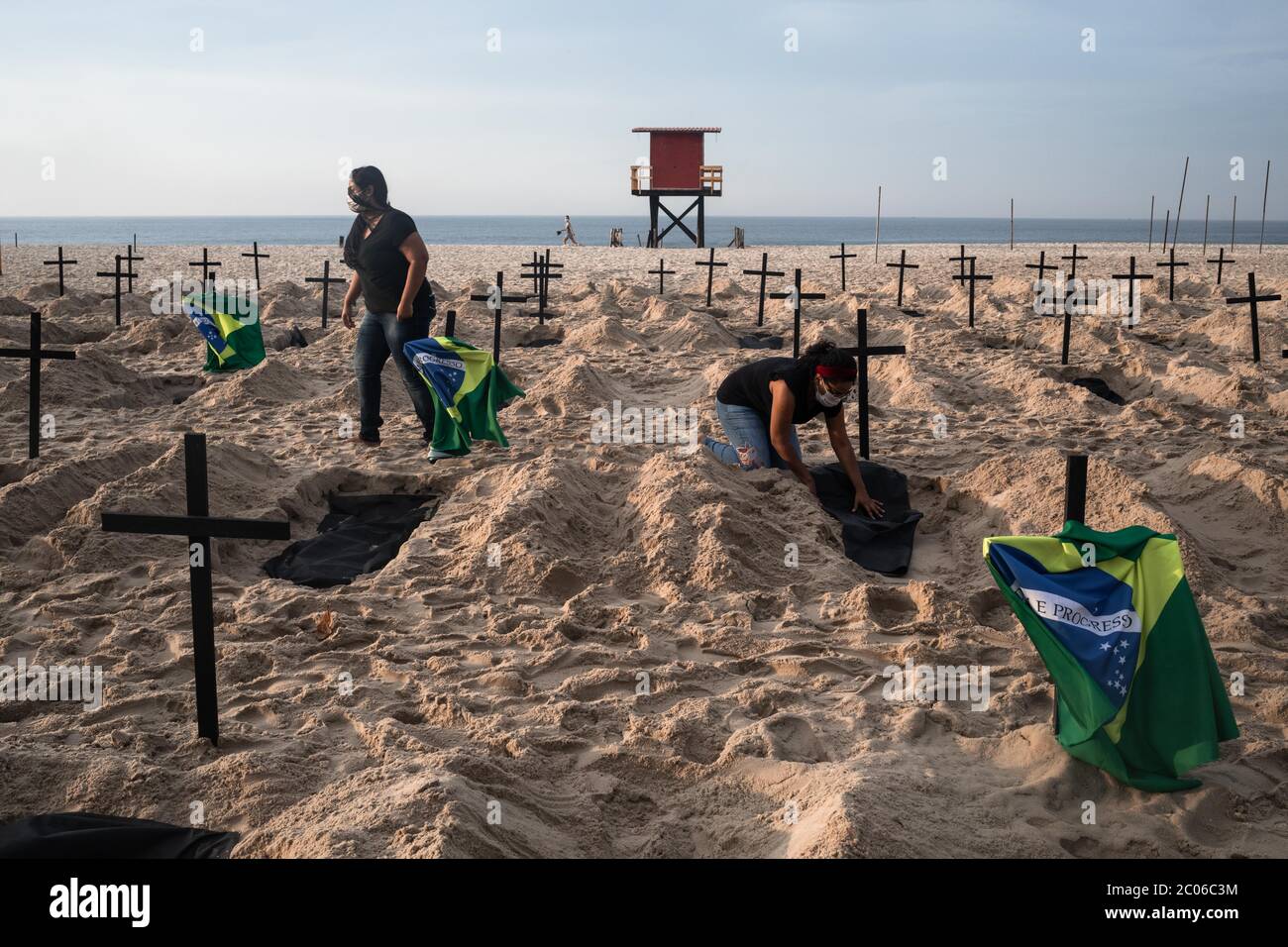 Rio De Janeiro, Brasilien. Juni 2020. Aktivisten der NGO Rio de Paz graben am Strand der Copacabana Gräber, um die Opfer von Corona zu symbolisieren und gegen den Umgang der Regierung mit der Krise zu protestieren. Brasilien ist das am stärksten von der Corona-Virus-Pandemie betroffene Land in Lateinamerika. Kredit: Ian Cheibub/dpa/Alamy Live News Stockfoto