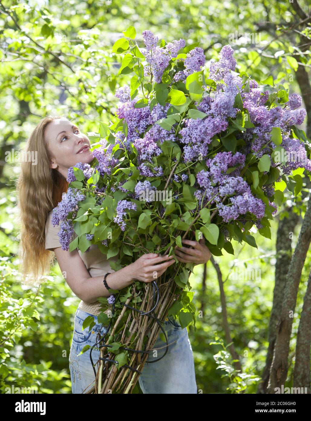 Frau im Park mit einem großen Blumenstrauß ein lila Stockfoto
