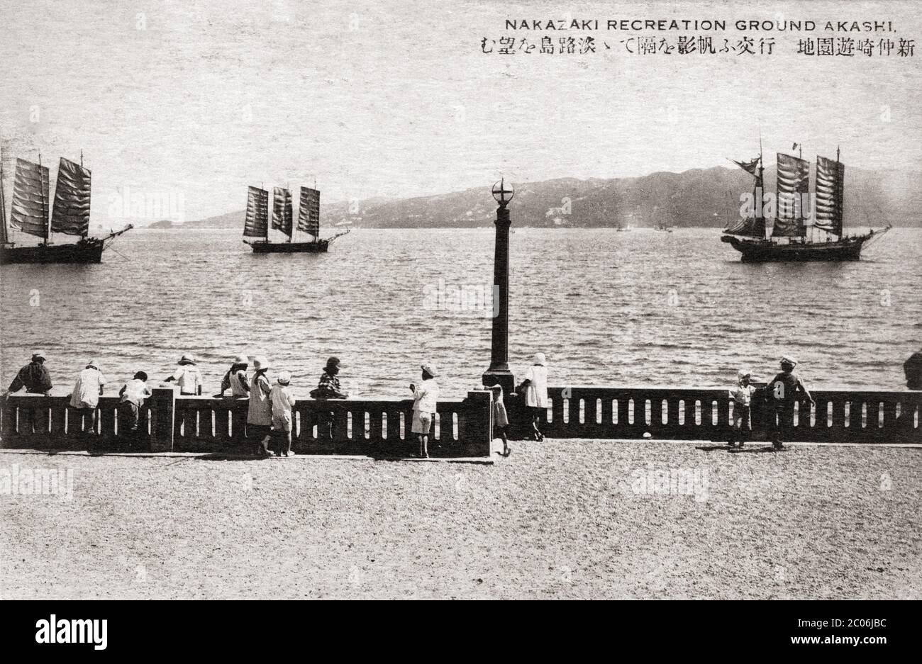 [ Japan der 1920er Jahre - Japanische Segelschiffe ] - Kinder beobachten Segelschiffe auf dem Nakazaki Erholungsgebiet in Akashi, Präfektur Hyogo. Im Hintergrund ist die Insel Awajishima sichtbar. Vintage-Postkarte des 20. Jahrhunderts. Stockfoto