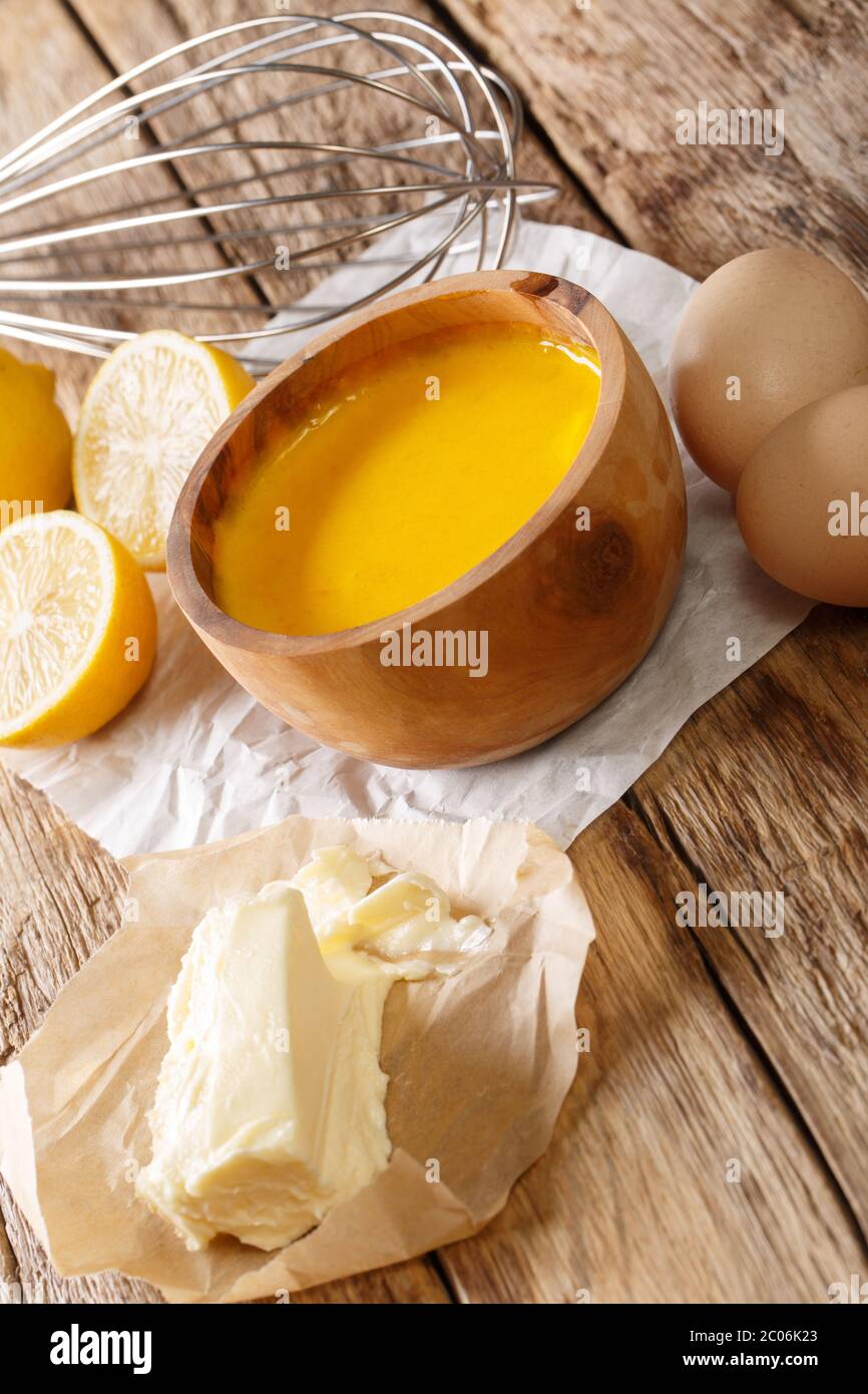 Frisch zubereitete Sauce Hollandaise mit Zutaten aus nächster Nähe auf dem Tisch. Vertikal Stockfoto