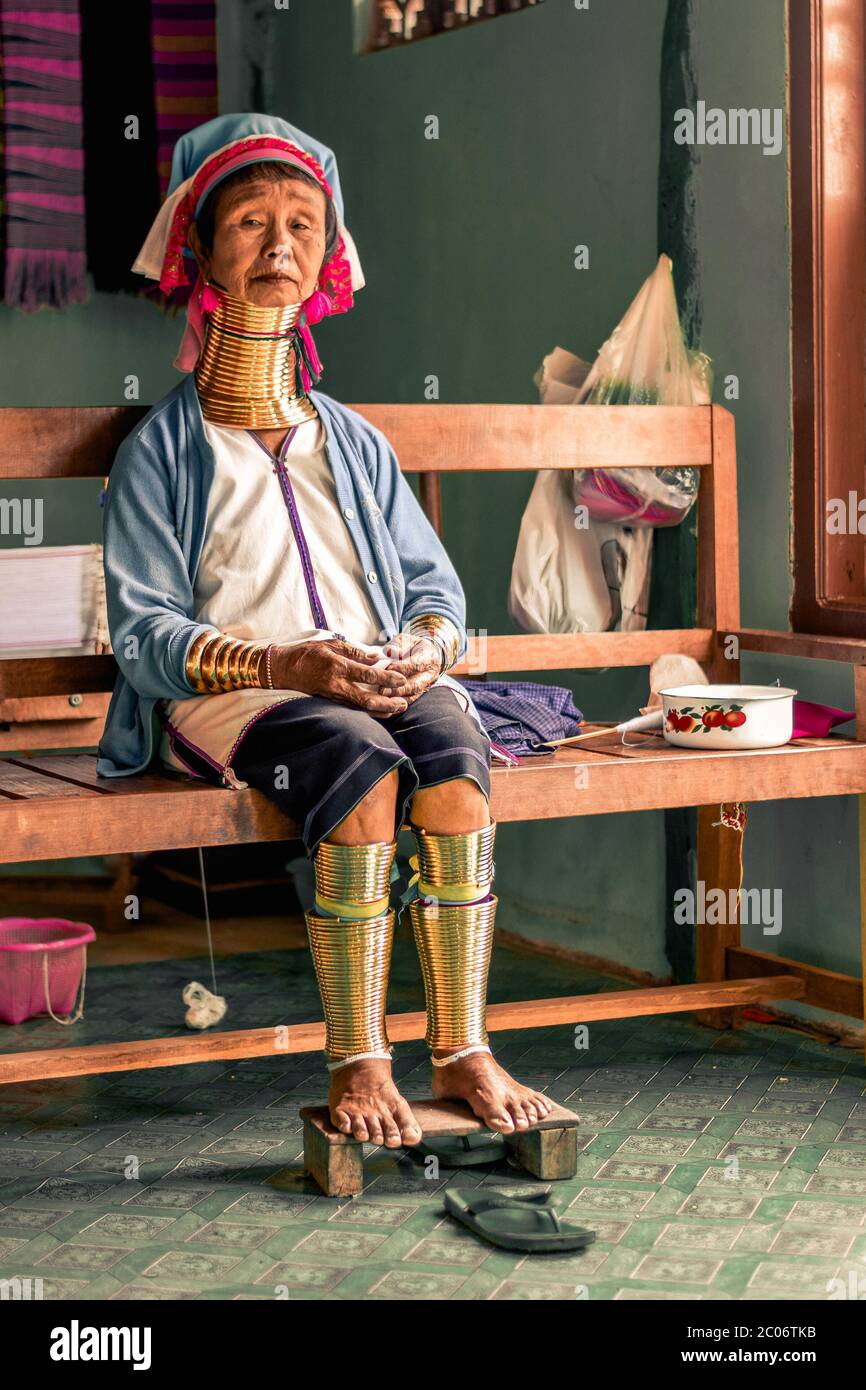 Frau mit langem Hals aus dem Kayan Stamm sitzt auf einer Bank am Inle Lake in Myanmar Burma Stockfoto