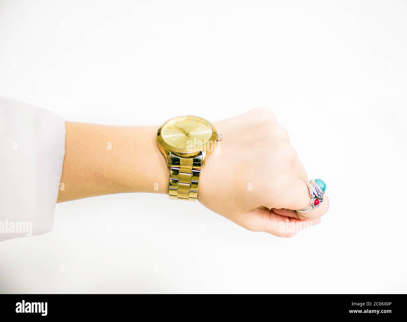 Weiblicher Arm zeigt die Zeit auf der goldenen Uhr an Stockfoto