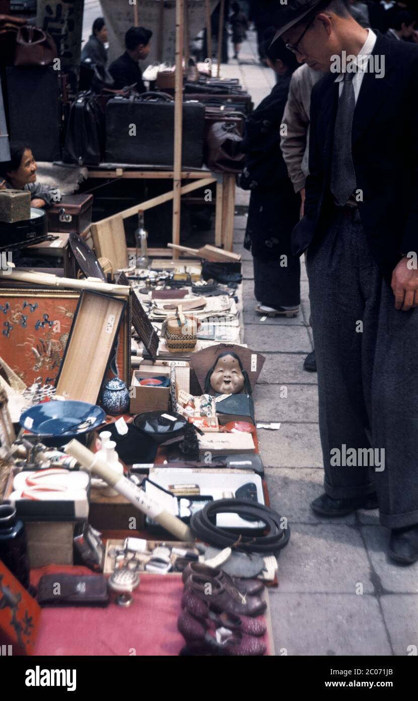 [ 1950er Japan - Bürgersteig-Verkäufer ] - EIN Japaner beobachtet gebrauchte Waren zum Verkauf durch einen Bürgersteig-Verkäufer auf Ginza, Tokyo, Ca. 1950 (Showa 25). Vintage Dia Film des 20. Jahrhunderts. Stockfoto