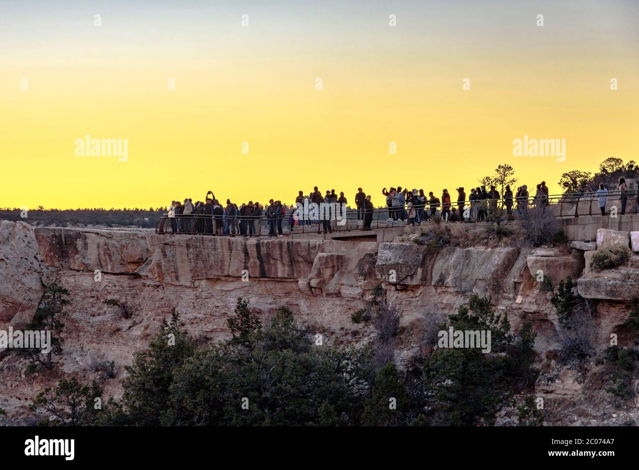Menschen auf einer Klippe erwarten den Sonnenaufgang im Grand Canyon Village Stockfoto