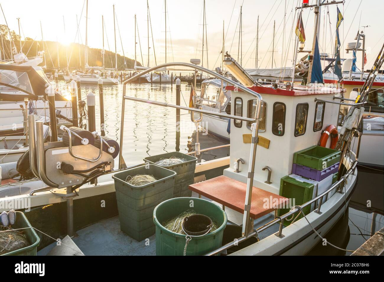 Kleines Fischerboot, das bei einem malerischen Sonnenuntergang im Hafen ankern kann Stockfoto