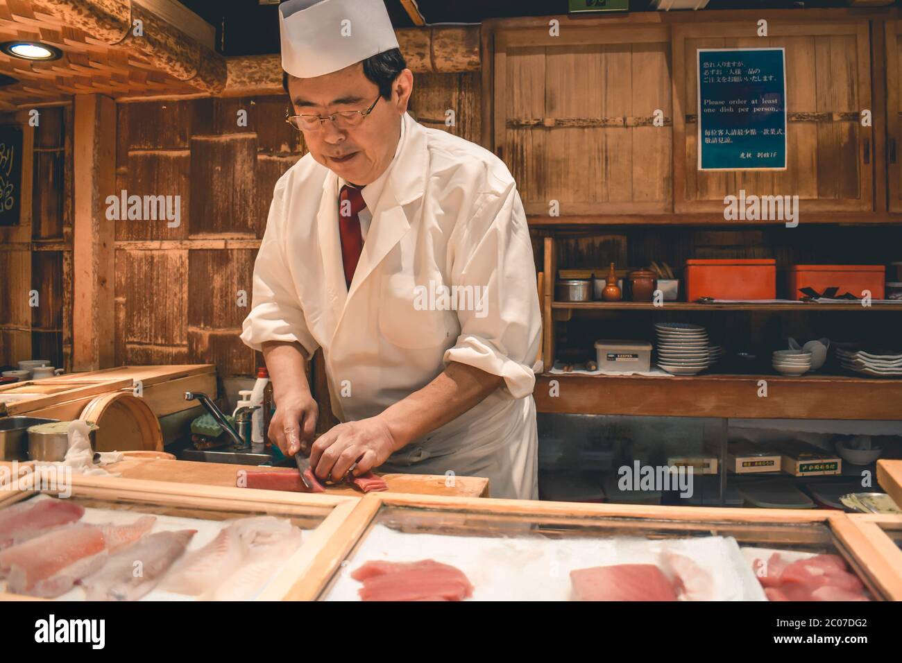 Sushi-Chefkoch bereitet auf dem Tsukiji-Fischmarkt in Tokio Japan frisches Thunfisch-Sashimi-Frühstück zu Stockfoto