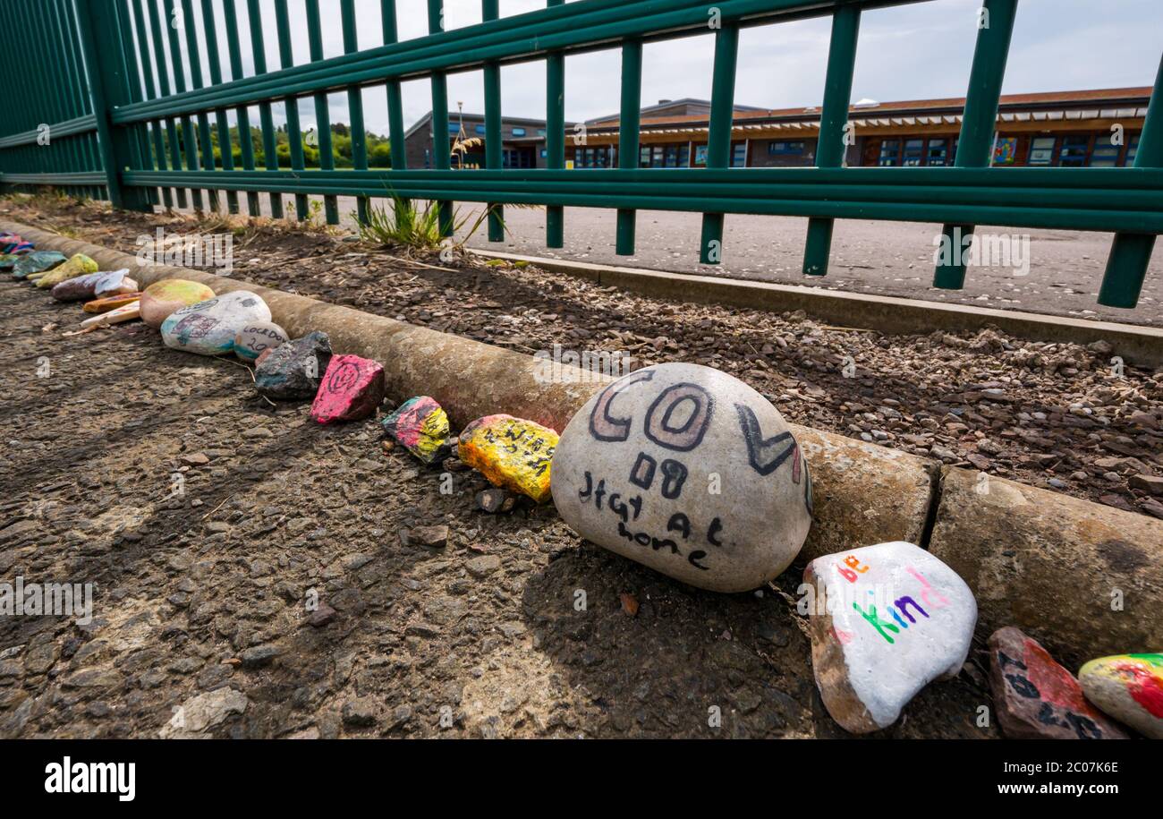 Tranent, East Lothian, Schottland, Großbritannien. Juni 2020. Covid-19 Pandemiesymbole von Einheimischen: Handbemalte Steine mit farbenfrohen und kreativen inspirierenden Botschaften am Zaun der Windygoul-Grundschule. Es scheint ein Phänomen zu sein, das sich in den Städten und Dörfern von East Lothian verbreitet Stockfoto