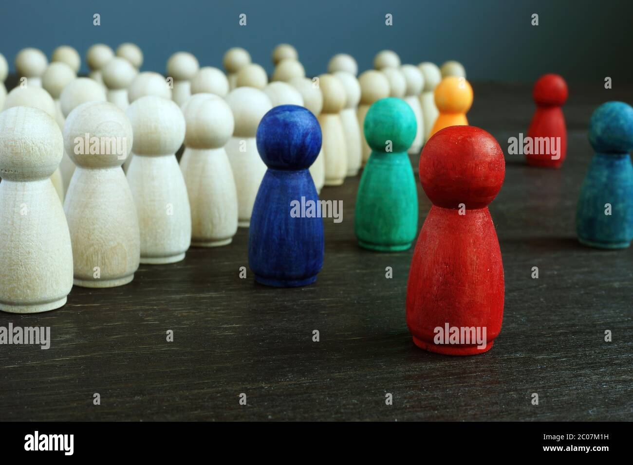 Konzept der Einbeziehung und Diskriminierung. Linien von Holzfiguren und verschiedene als Symbol der Vielfalt. Stockfoto