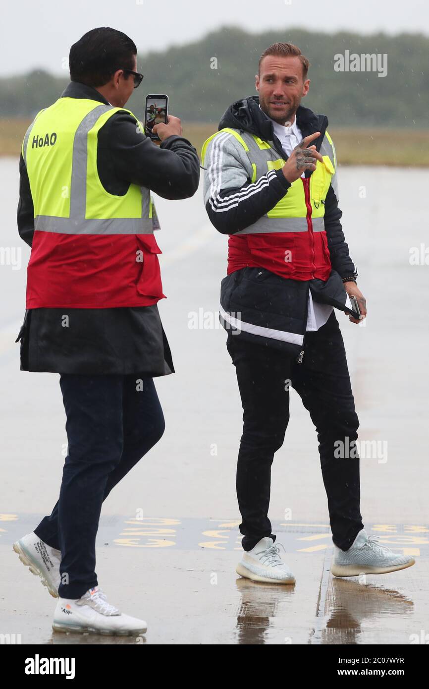 Calum Best (rechts) und Tamer Hassan posieren für Fotos, während Kisten mit persönlicher Schutzausrüstung (PSA) aus einem Flugzeug am Robin Hood Airport in Doncaster, South Yorkshire, entladen werden. 30,000 PPE wurden der Mask Our Heroes Charity gespendet, die von dem Schauspieler Tamer Hassan nach dem Ausbruch des Coronavirus ins Werk gesetzt wurde, um die NHS und die Gesundheitskräfte vor Ort mit der benötigten Schutzausrüstung zu versorgen. Stockfoto