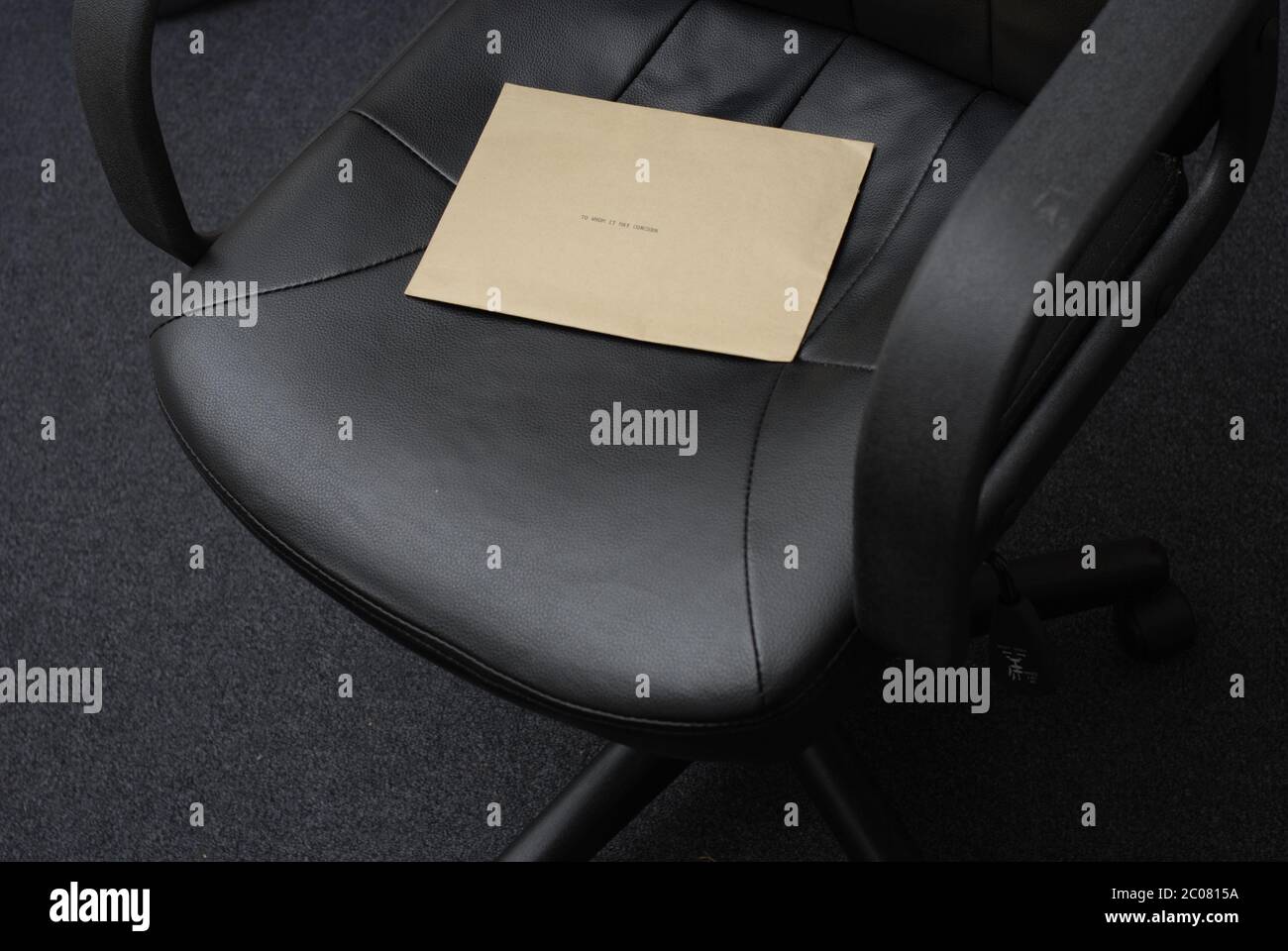 An wen es sich möglicherweise handelt. Geheimnisvolle Nachricht auf einem Bürostuhl hinterlassen. Brauner Manilla Umschlag auf Sitz hat die Wörter, an wen es möglicherweise betreffen, die auf ihm geschrieben werden. Stockfoto