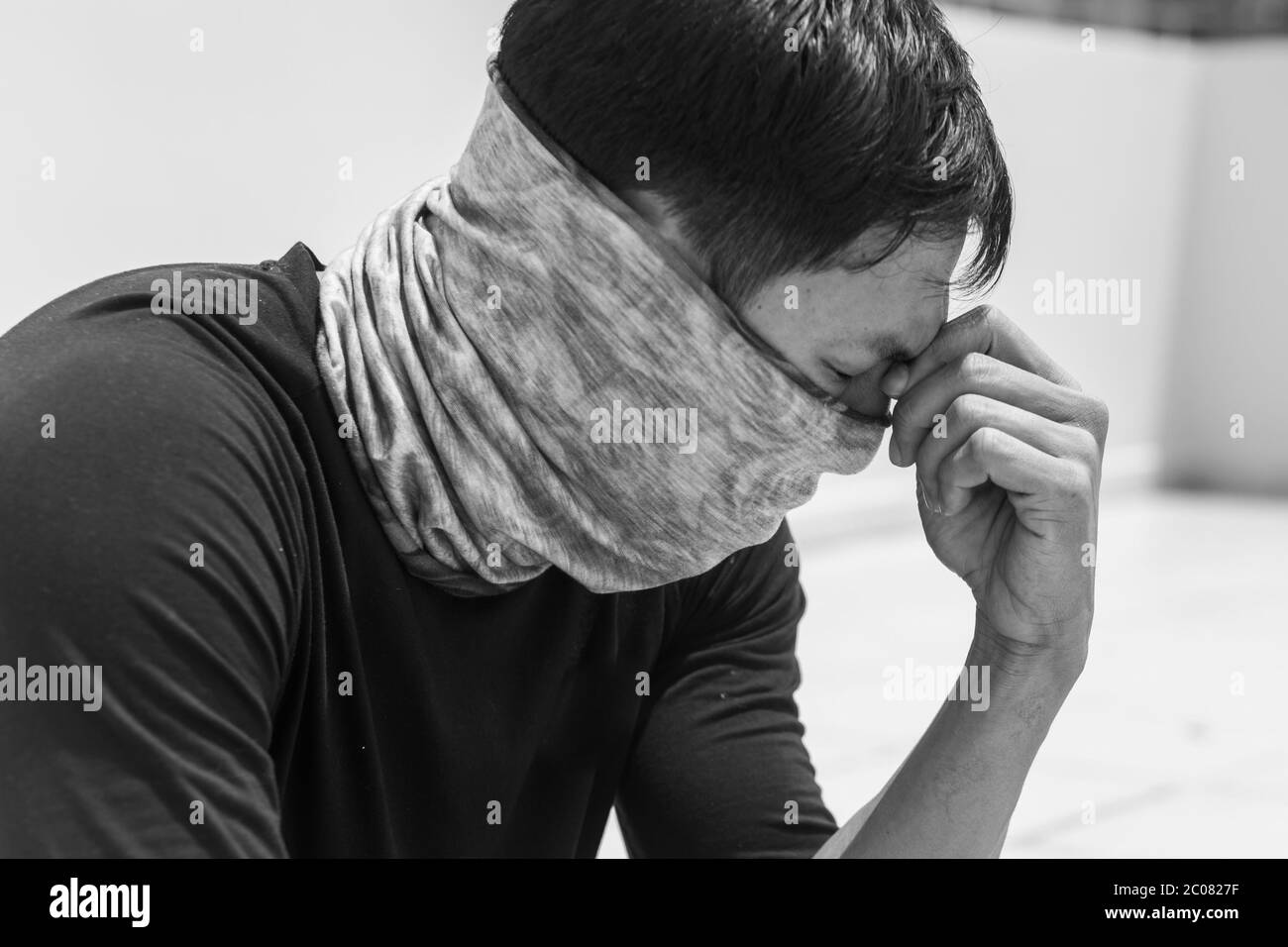 Der Chinese, der sein Gesicht bedeckt, machte sich Sorgen, krank zu werden und trug eine Maske in der Stadt. Stockfoto