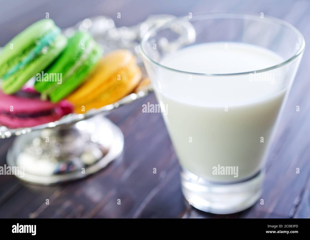 Milch im Glas und Farbe Makronen Stockfoto