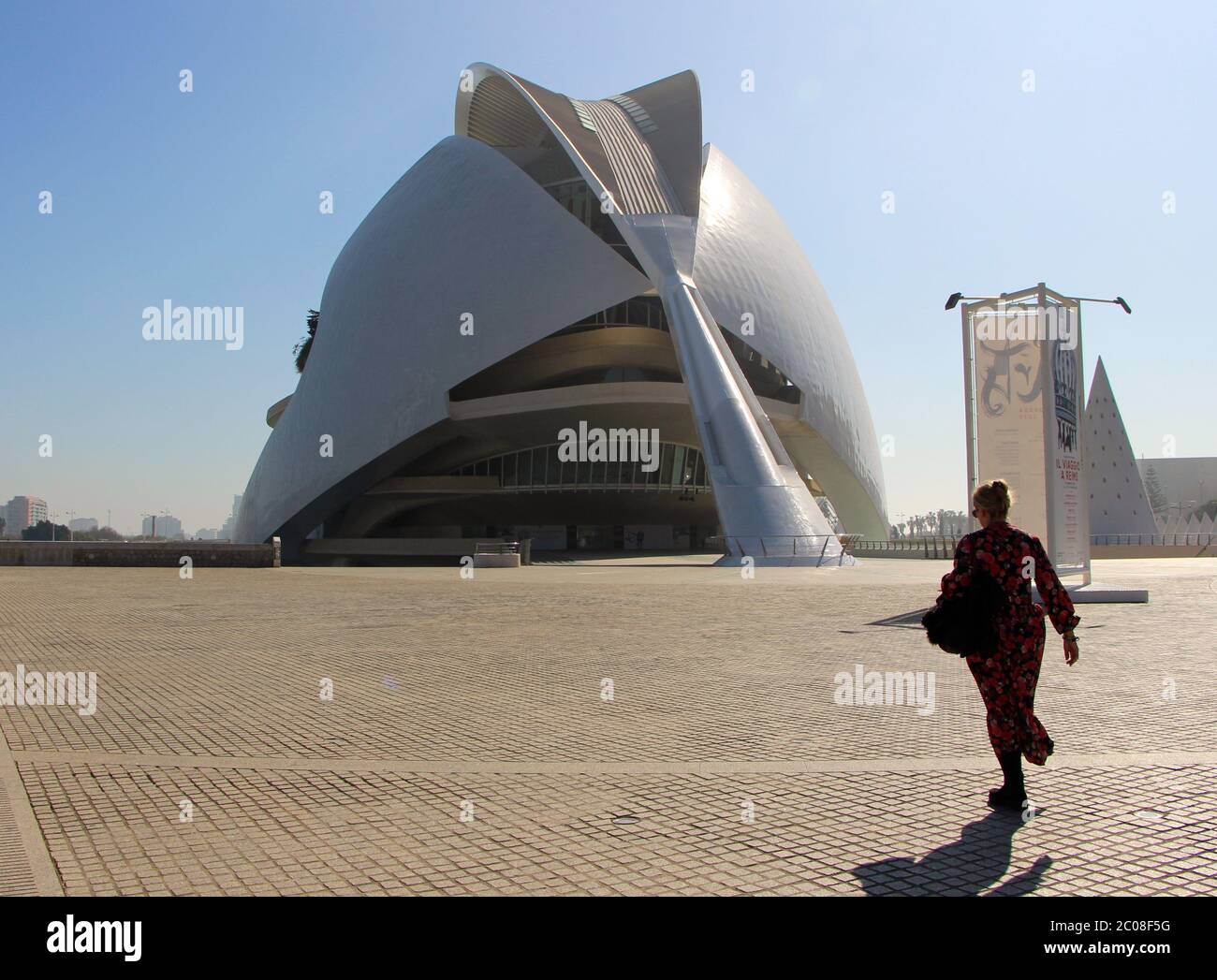 Eine Frau, die in Richtung Palau de les Arts reina geht sofia Gebäude in der Stadt der Künste und Wissenschaften auf Ein sonniger Tag moderne Architektur Valencia Stockfoto