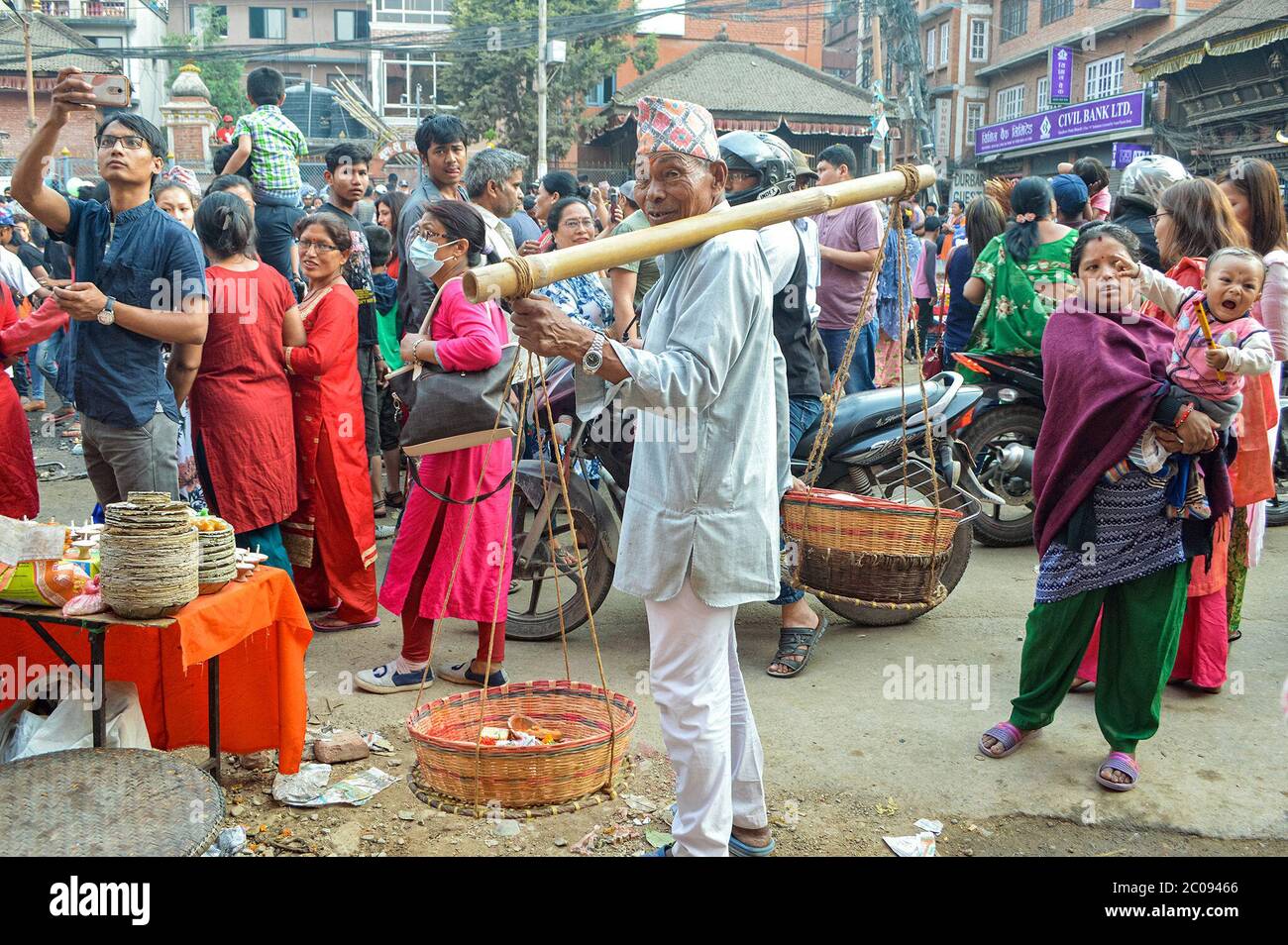 Anish Shakya sammelt während eines Festivals, das Rato Machindranath feiert, eine Gottheit, von der man glaubt, dass sie Macht über Regen hat, in Kathmandu, Nepal, Opfergaben in einem Korb. (Yam Kumari Kandel, GPJ Nepal) Stockfoto