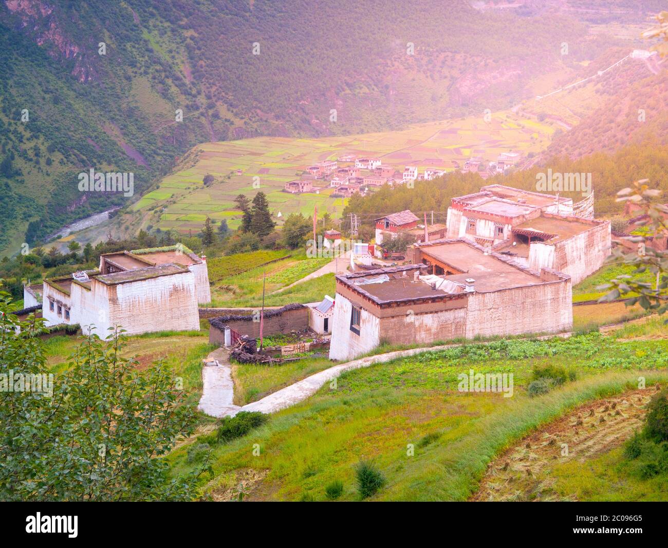 Grüne hügelige Landschaft Tibets mit kleinen traditionellen tibetischen Dorf. Stockfoto