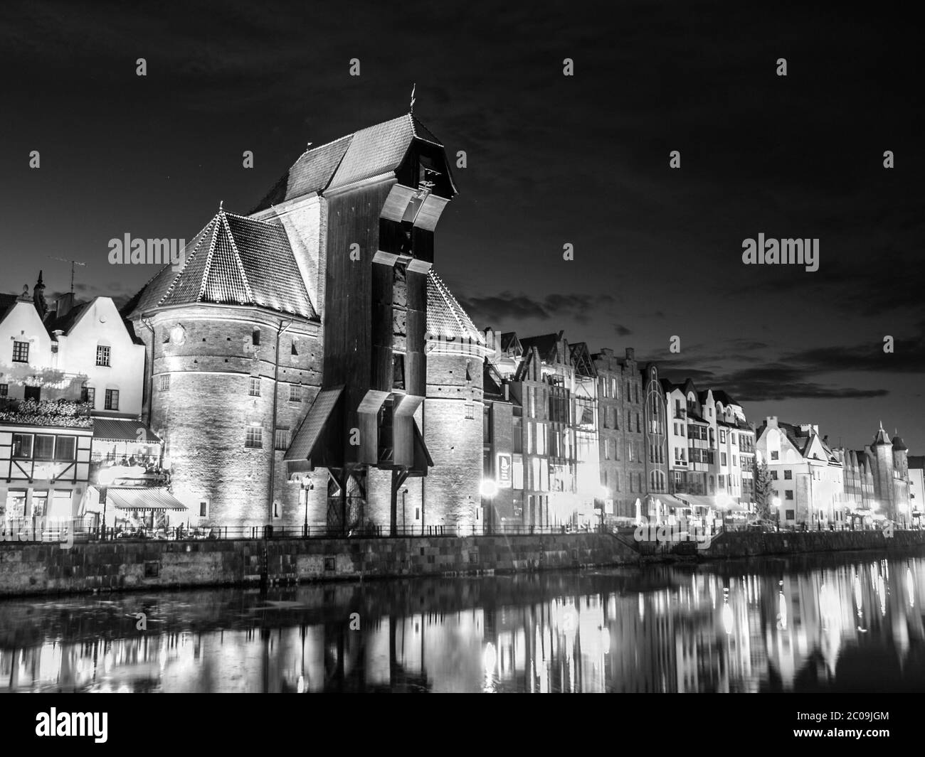 Danzig bei Nacht mit altem Kran und Reflexion in Motlawa Fluss, Polen. Schwarzweiß-Bild. Stockfoto