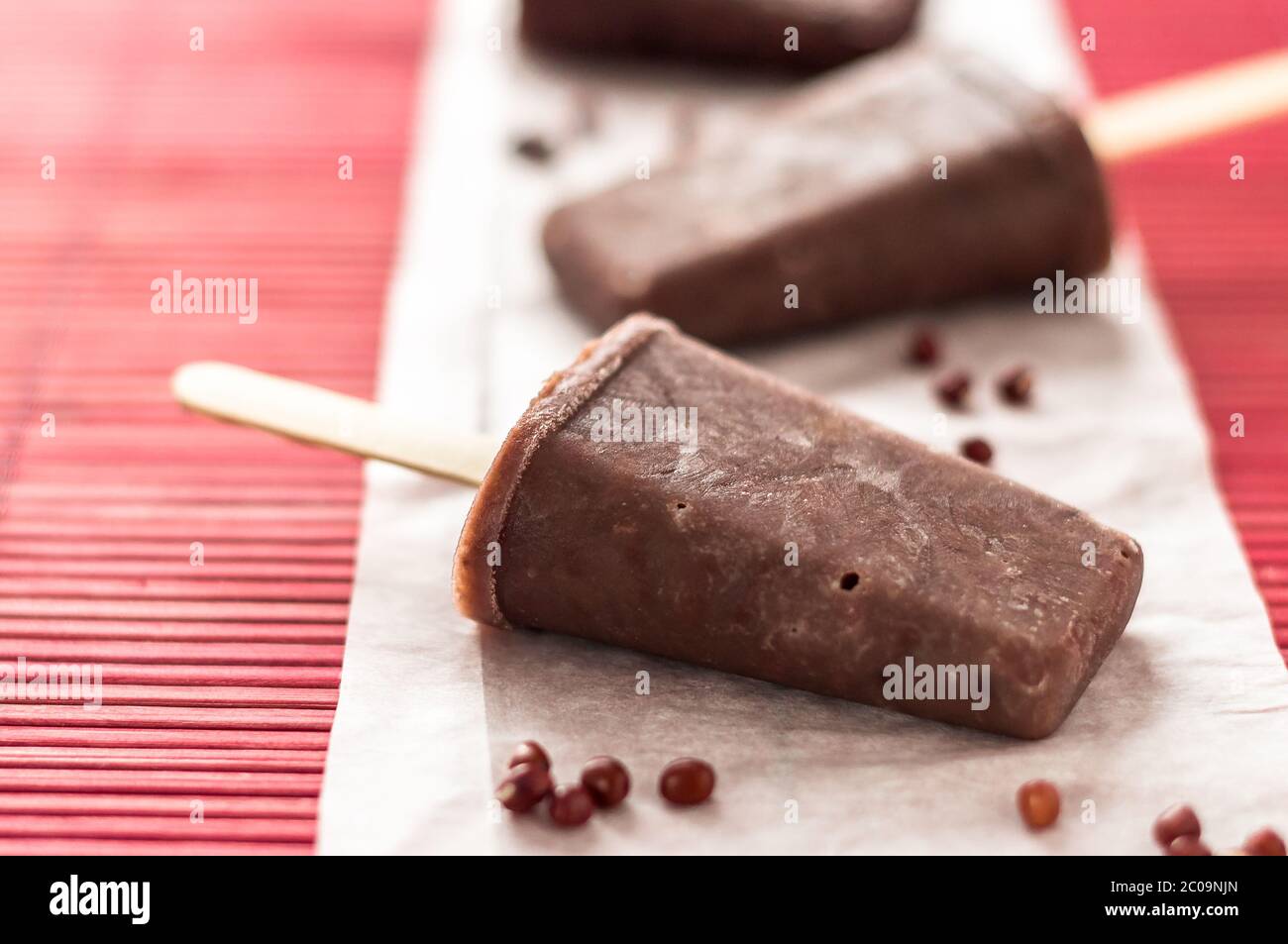 Rote Adzuki Bohnen, Eiszapfen. Eisdielen sind eine köstliche Art, sich an heißen Sommertagen abzukühlen, diese bestehen aus rotem Adzuki-Bohnen-Eis, einem winzigen asiatischen Su Stockfoto