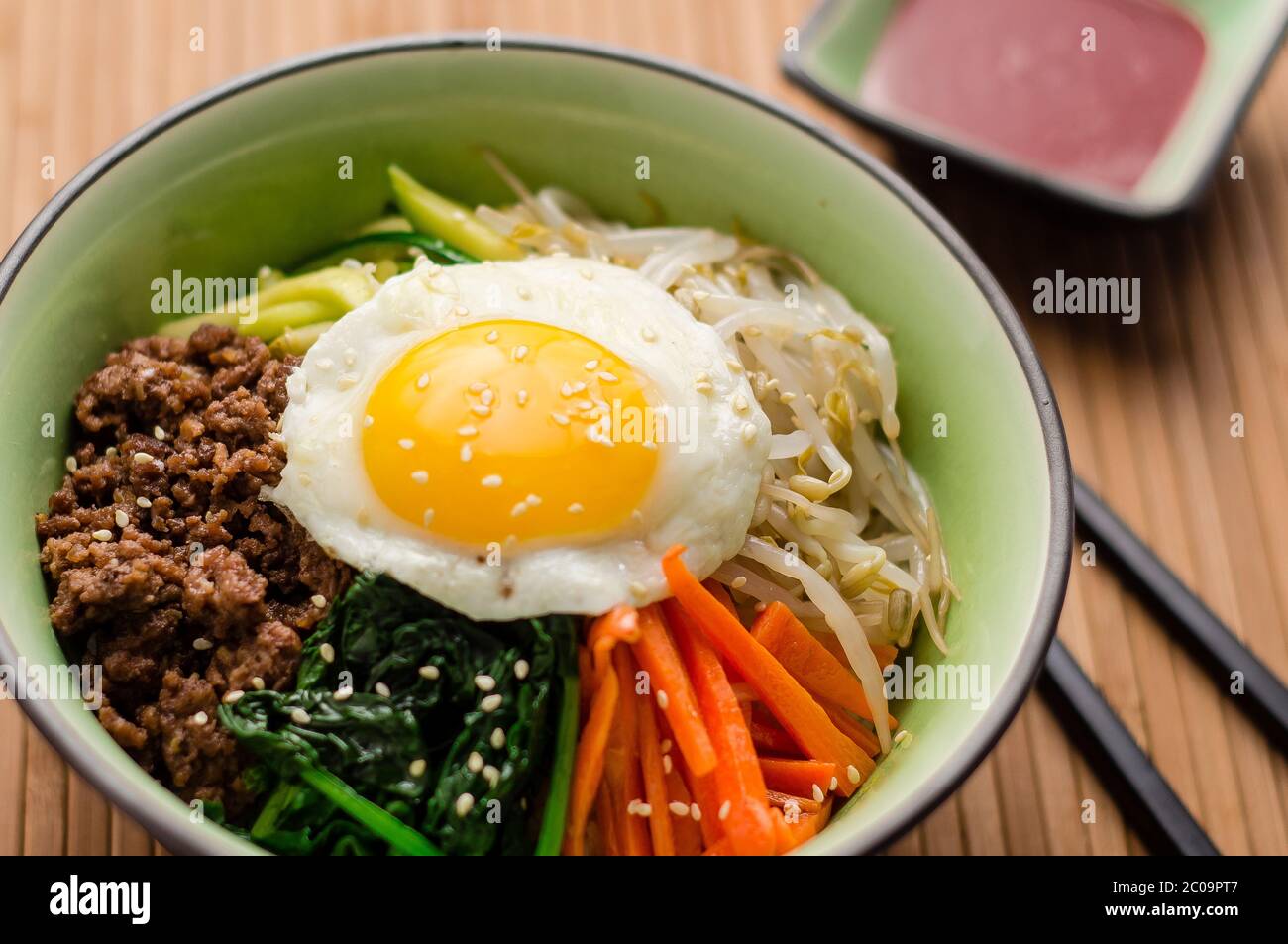 Bibimbap ist ein klassisches koreanisches Gericht. Eine Schüssel Reis wird mit gewürztem Gemüse, Fleisch und einer sonnigen Seite oben Spiegelei auf gekrönt. Stockfoto Bibimbap ist ein klassisches koreanisches Gericht. Eine Schüssel Reis wird mit gewürztem Gemüse, Fleisch und einer sonnigen Seite oben Spiegelei auf gekrönt. Stockfoto
