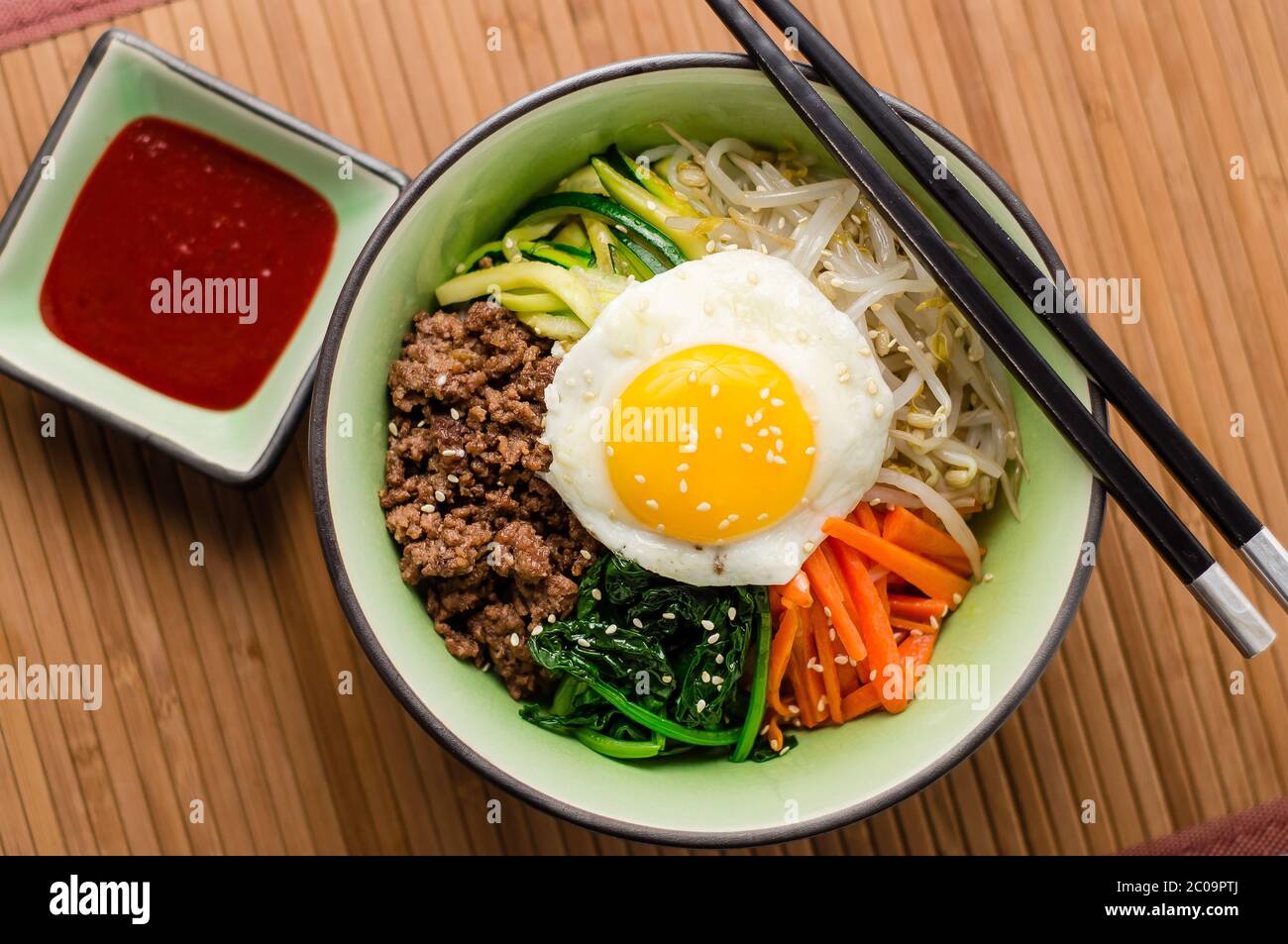 Bibimbap ist ein klassisches koreanisches Gericht. Eine Schüssel Reis wird mit gewürztem Gemüse, Fleisch und einer sonnigen Seite oben Spiegelei auf gekrönt. Stockfoto Bibimbap ist ein klassisches koreanisches Gericht. Eine Schüssel Reis wird mit gewürztem Gemüse, Fleisch und einer sonnigen Seite oben Spiegelei auf gekrönt. Stockfoto