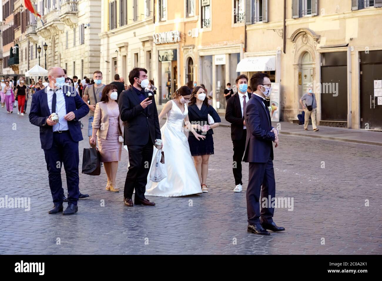 Frisch verheiratetes Paar und einige Freunde, die zur Hochzeit eingeladen wurden, tragen eine medizinische Maske für das Covid 19 Coronavirus, gehen Sie zur Spanischen Treppe. Rom zur Zeit von Covid 19 Phase 2, zwei. Italien, Europa, Europäische Union, EU. Stockfoto