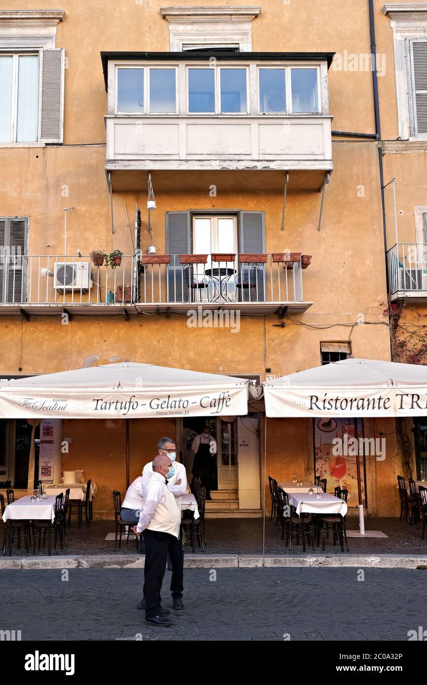 Kellner eines berühmten Restaurants auf der Piazza Navona, warten auf alle Kunden. Leere Tabellen wegen des Covid 19 Coronavirus. Rom zur Zeit von Covid 19. Italien, Europa, Europäische Union, EU. Stockfoto
