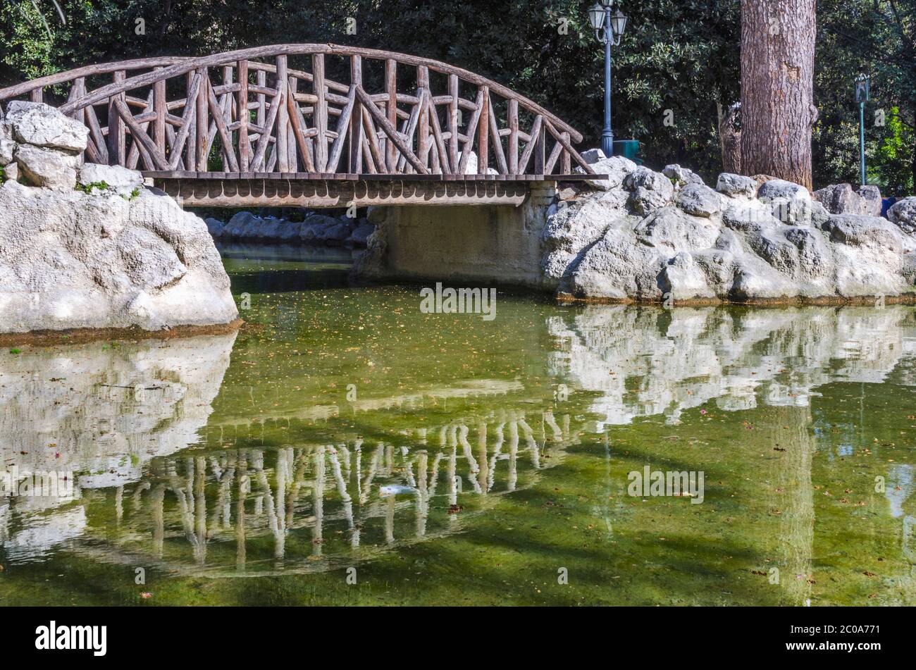 Der kleine künstliche See mit der Holzbrücke, die sich auf dem See beim National Garden Public Paek in Athen Griechenland widerspiegelt Stockfoto