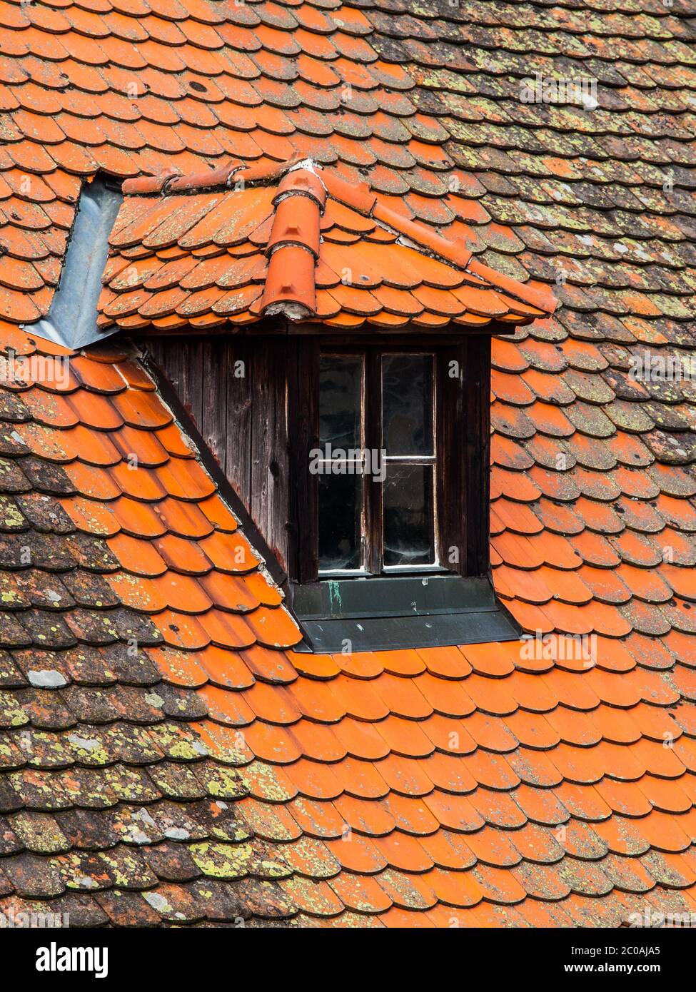 Altes orangefarbenes Dach mit Retro-Dachfenster Stockfoto