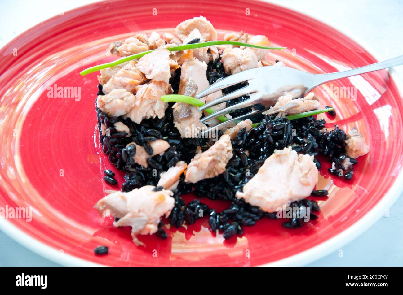 Schwarzer Reis mit Lachs Sahne und Petersilie Stockfoto