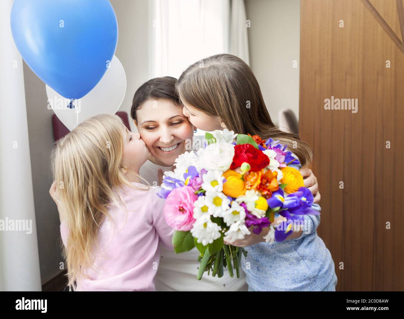 Glückliche Frau und ihre kleinen Töchter im Wohnzimmer Stockfoto