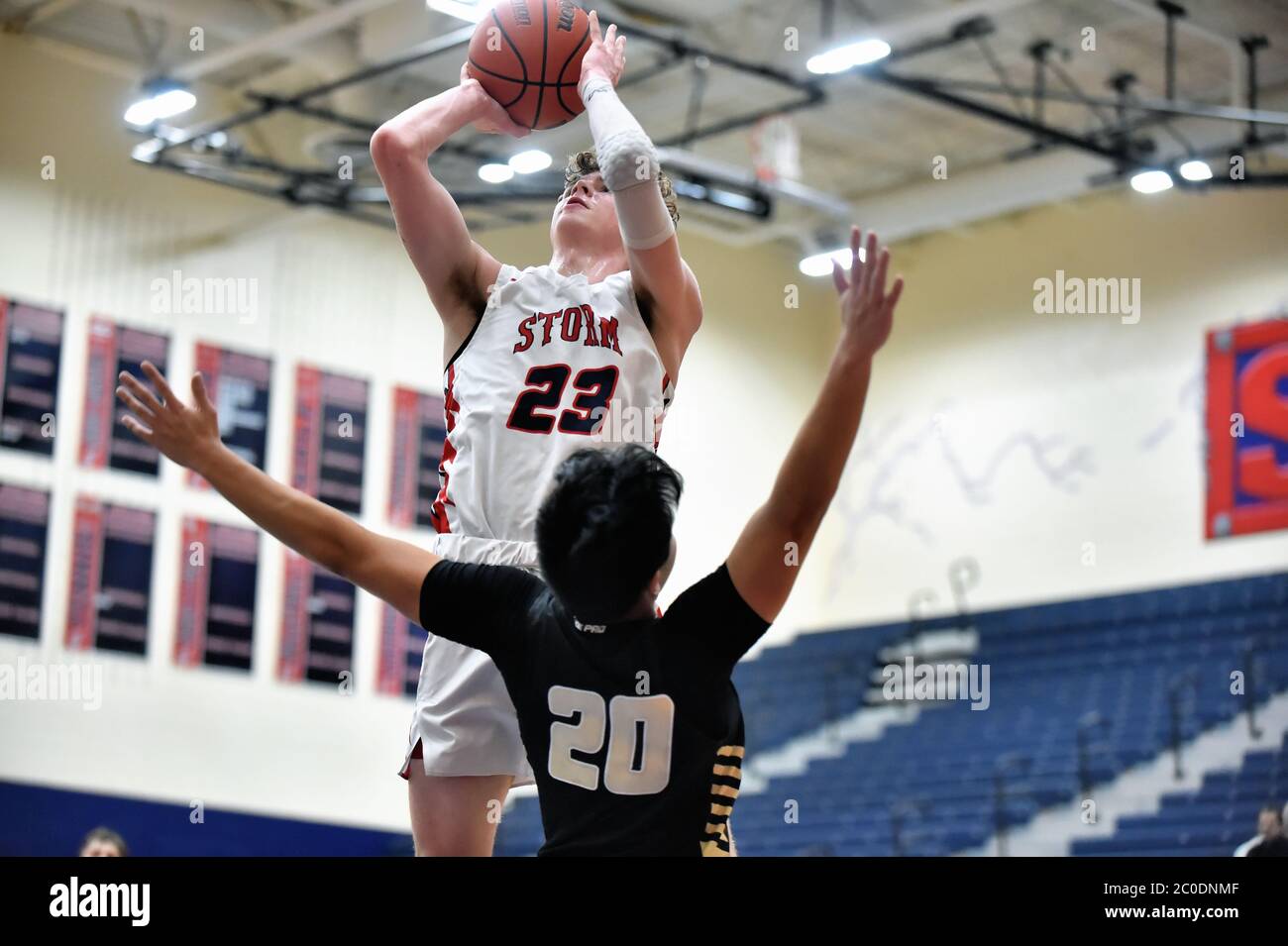 Spieler weit über dem Boden, der einen Sprung über einen ausladenden Verteidiger schießt. USA... Stockfoto