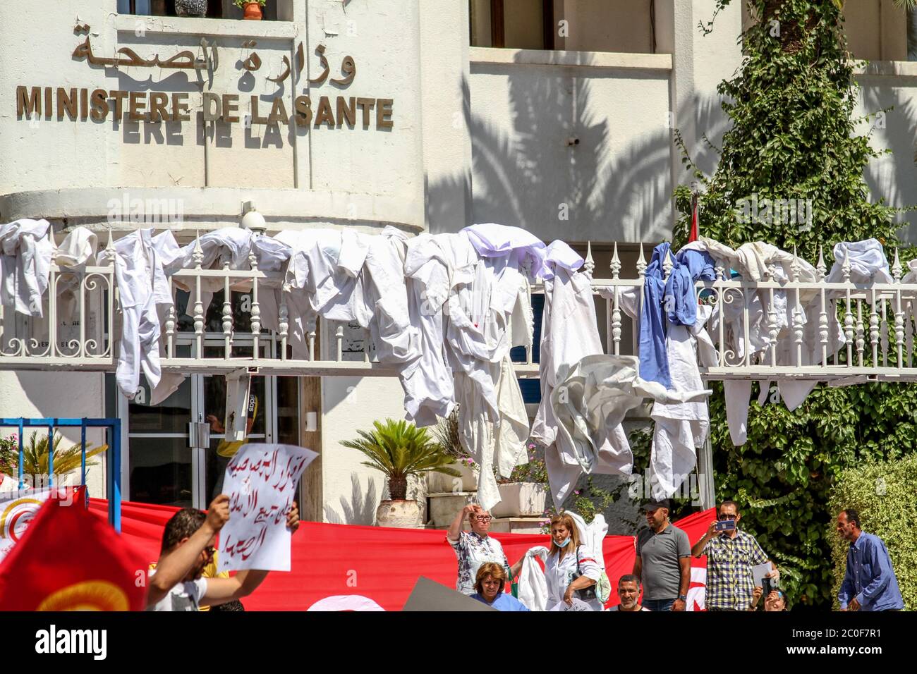 Tunis, Tunesien. Juni 2020. In Abstimmung mit dem allgemeinen Gesundheitsverband im Rahmen der tunesischen Gewerkschaft der allgemeinen Arbeitnehmer (UGTT), Mitglieder der Basisgewerkschaft des Charles Nicolle Krankenhauses werfen die weißen Mäntel an die Tür des Gesundheitsministeriums während eines Sitzes-in protestieren gegen die Nichtanwendung der zuvor geschlossenen Konventionen und fordern die Rücknahme von Artikel 2 des Gesetzes des öffentlichen Dienstes in Ordnung Die Möglichkeit, ein Statut zur Organisation des Gesundheitswesens zu veröffentlichen. Kredit: SOPA Images Limited/Alamy Live Nachrichten Stockfoto