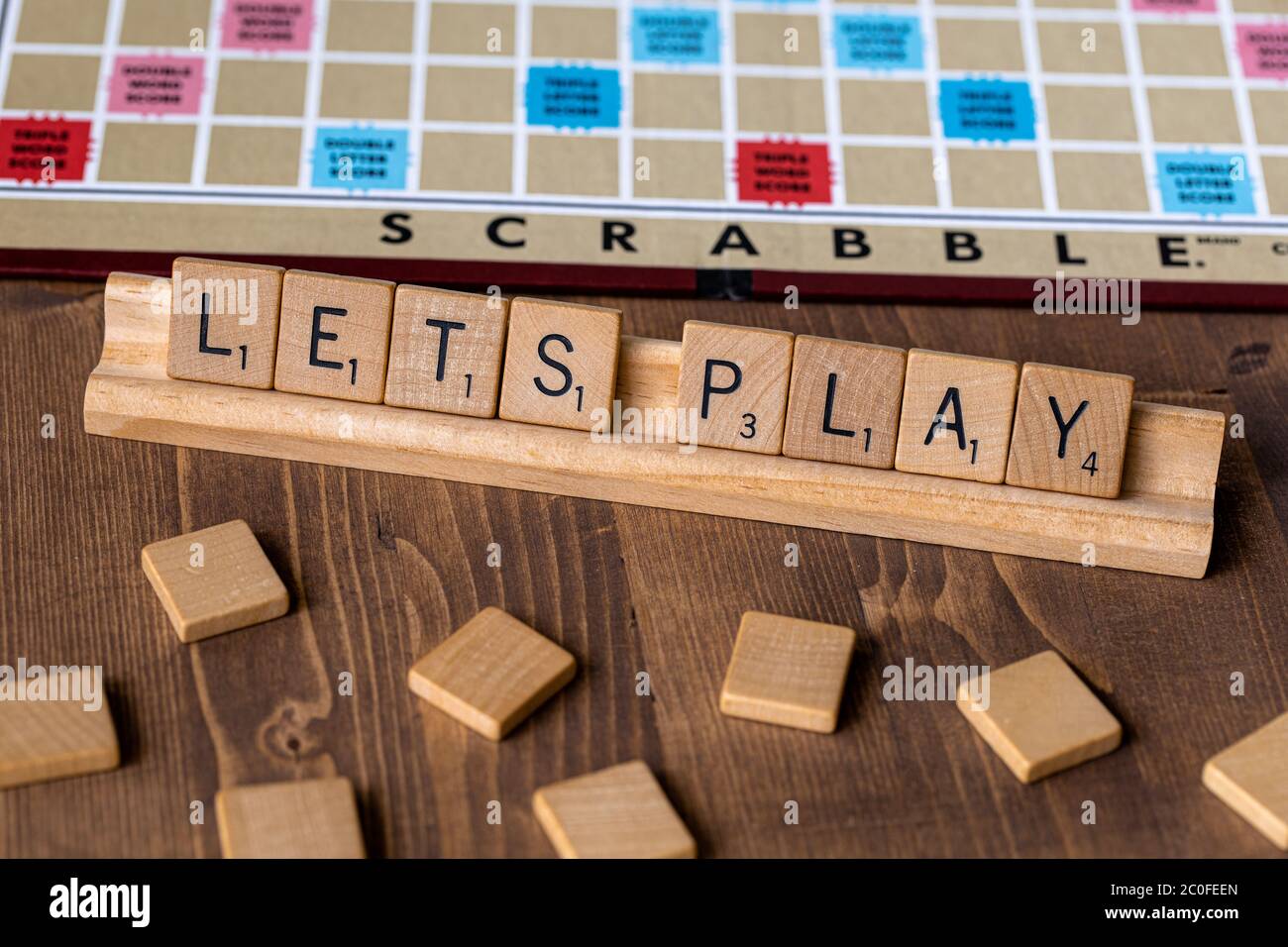 Scrabble Brettspiel mit der Scrabble Fliese Schreibweise "Lets Play" auf der Tischplatte Stockfoto