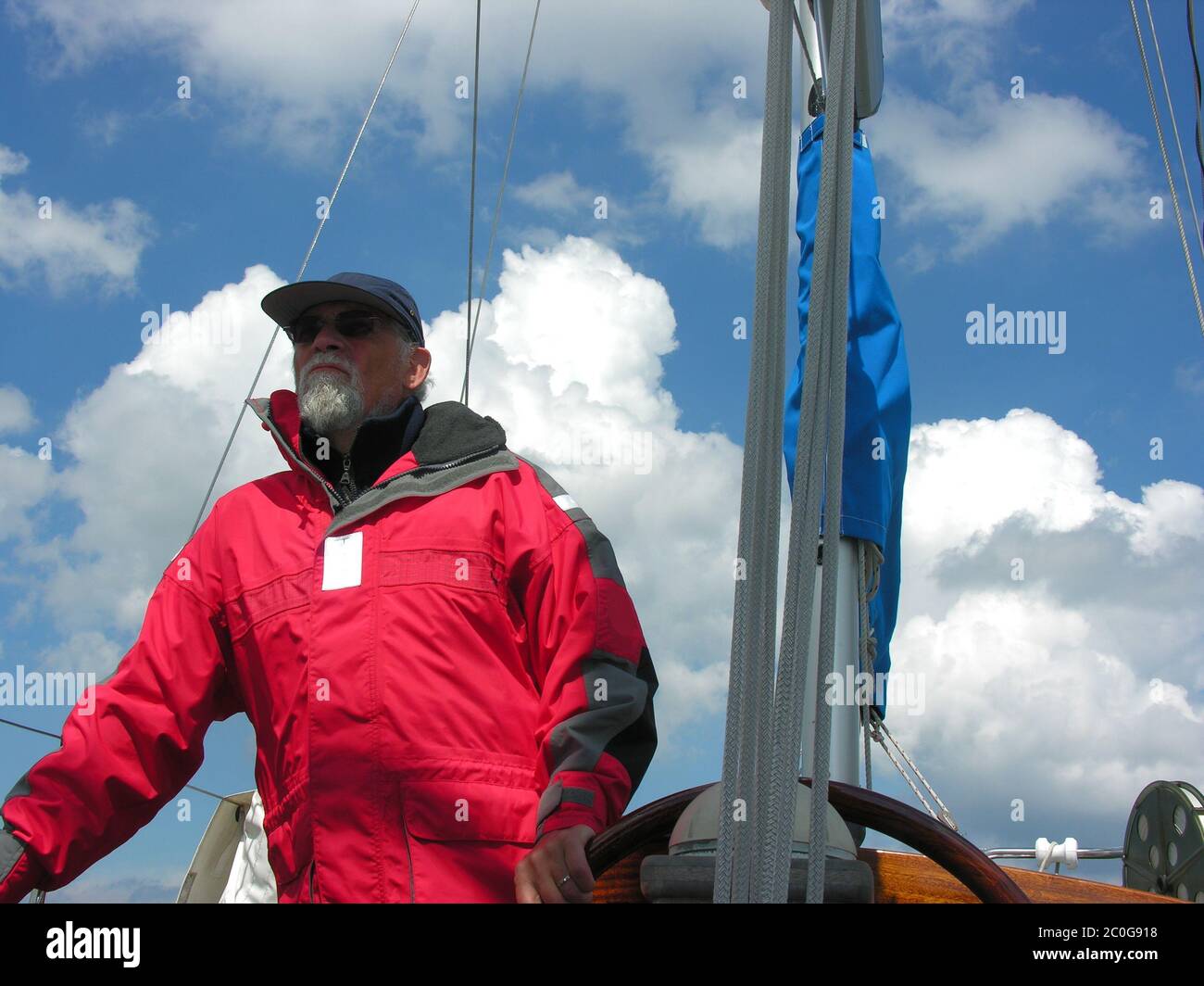 Älterer Mann steuert eine Yacht Stockfoto