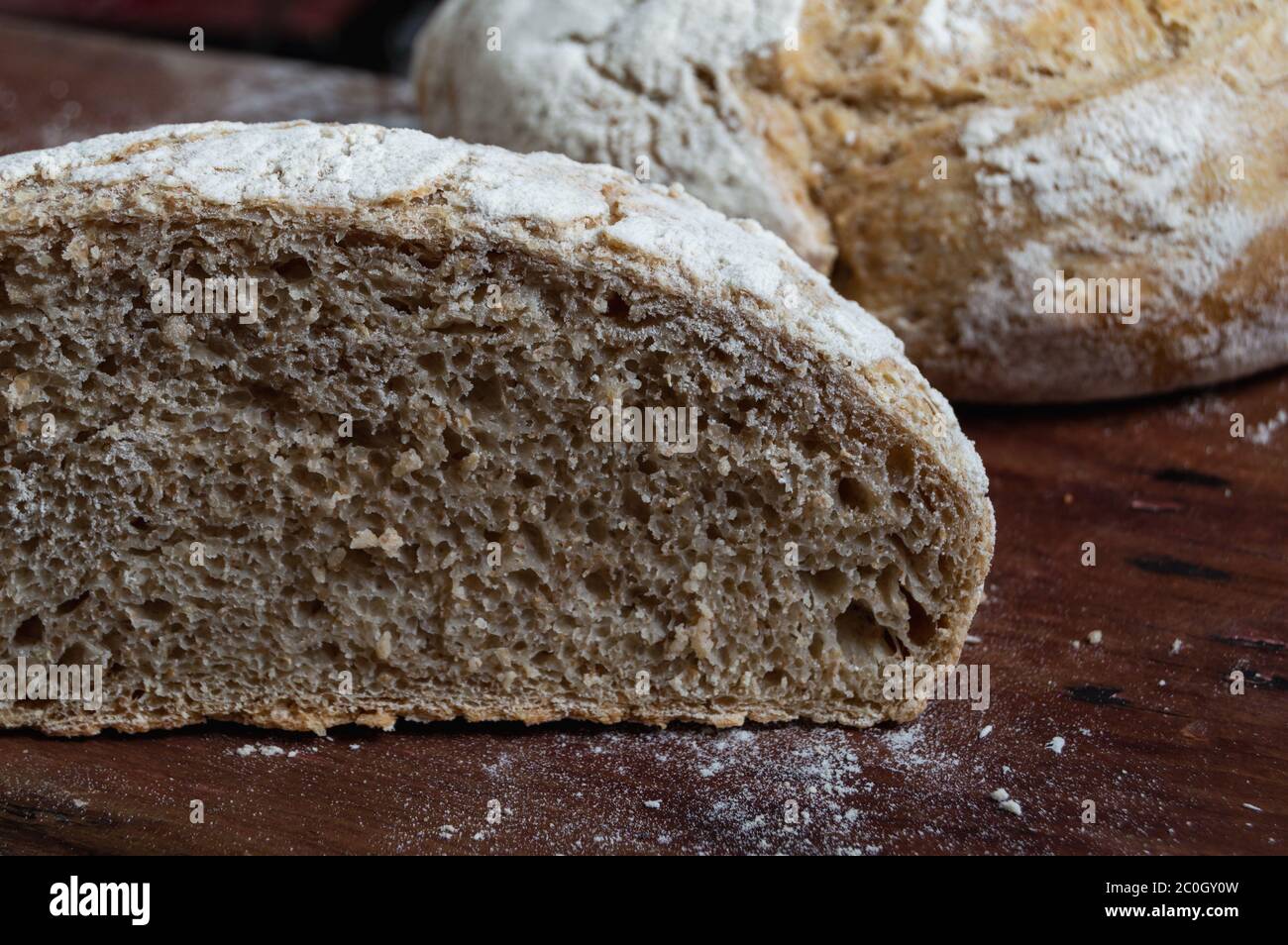 Frisch gebackenes hausgemachtes Brot in Korbkorb auf Holztisch Stockfoto