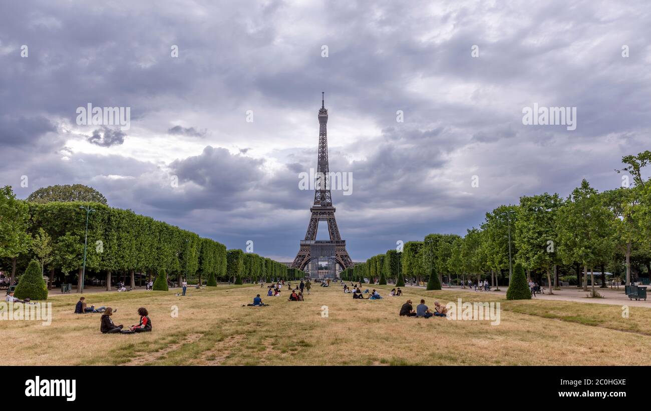 Paris, Frankreich - 10. Juni 2020: Die Pariser kehren nach der Sperre auf den Wiesen der Champs de Mars vor dem Eiffelturm zurück, um sich zu entspannen Stockfoto