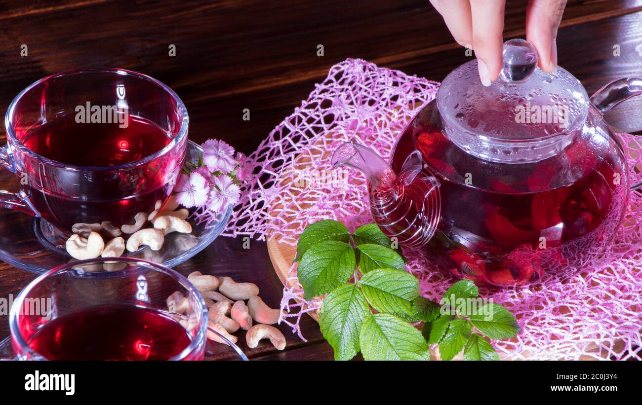 Eine Frau macht Tee. Roter Tee, Hibiskus, Karkade, Rooibos. Zeremonie, Nachmittagstee, Frühstück. Teezeit, Karkade. Orientalisch, gemütlich, Tradition, japanisch, le Stockfoto