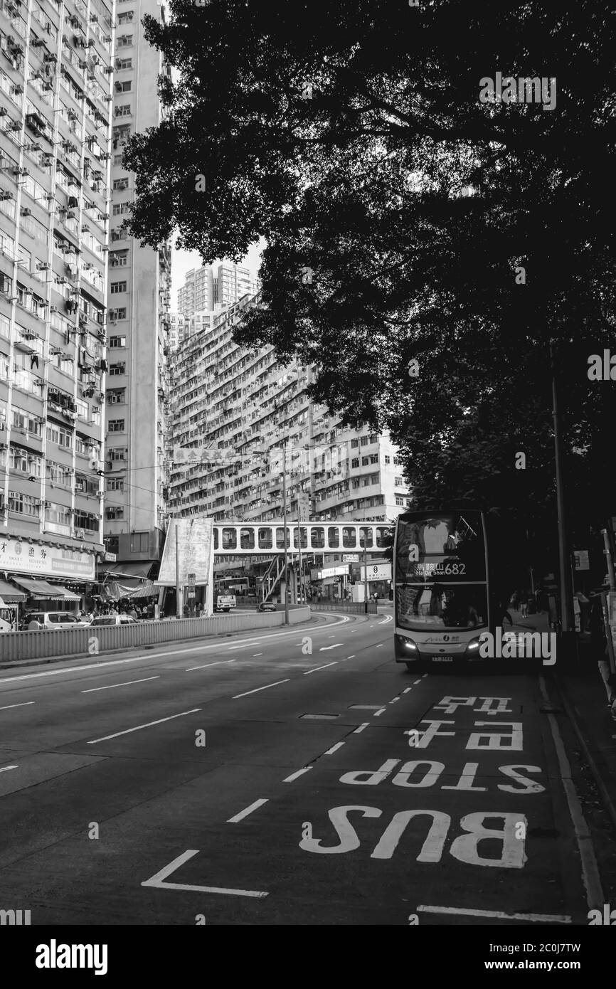 Doppeldeckerbus kommt zu einer Bushaltestelle in Wohngebiet von Hong Kong Stockfoto