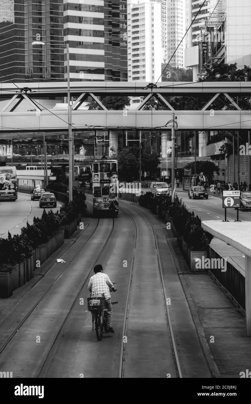 Betrunkener Mann auf einem Fahrrad fahren in der Gegend gewidmet Doppeldecker-Straßenbahnen in Hongkong China Stockfoto