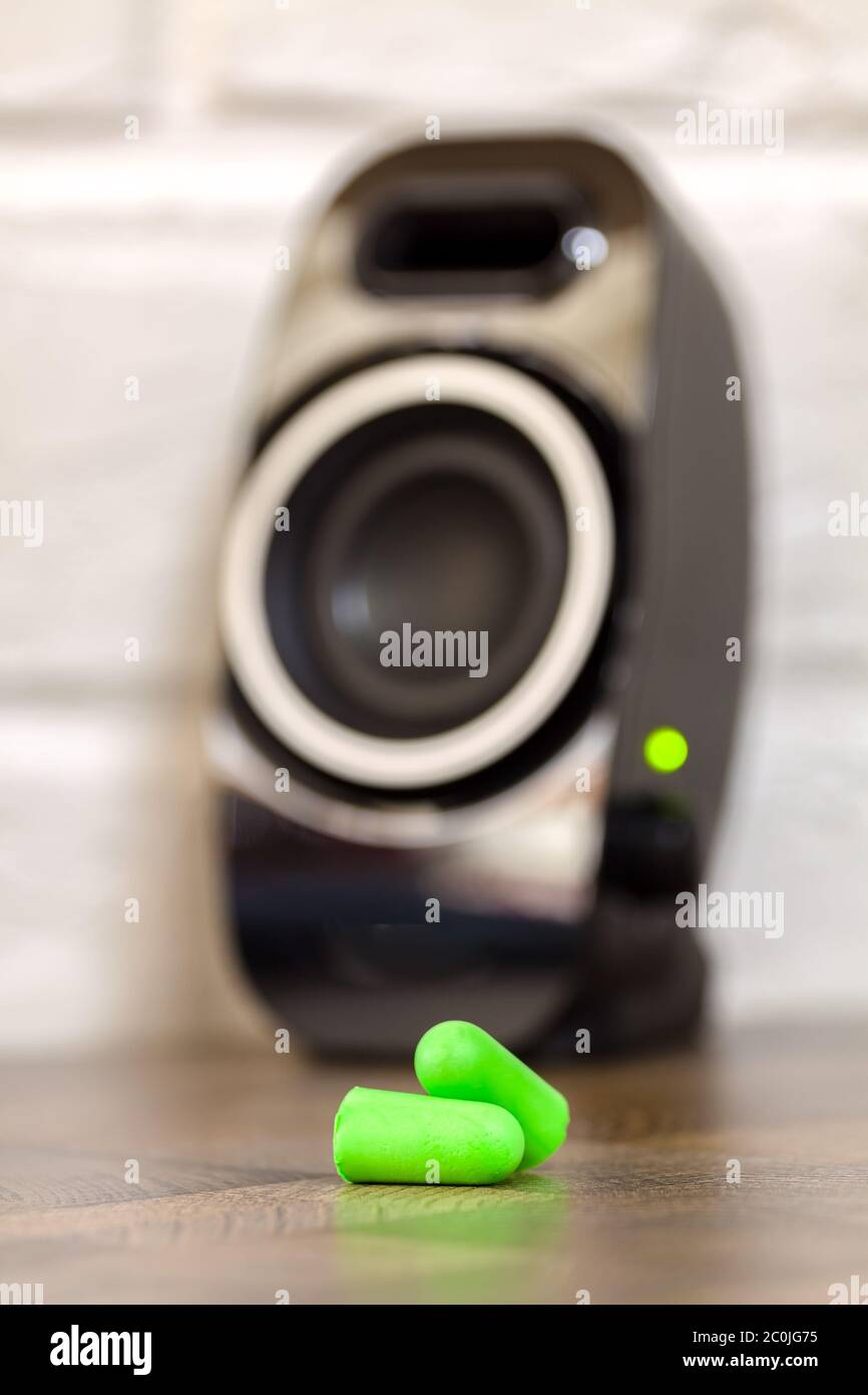 Grüne Schaumstoffohrstöpsel nahe am Lautsprecher Stockfoto