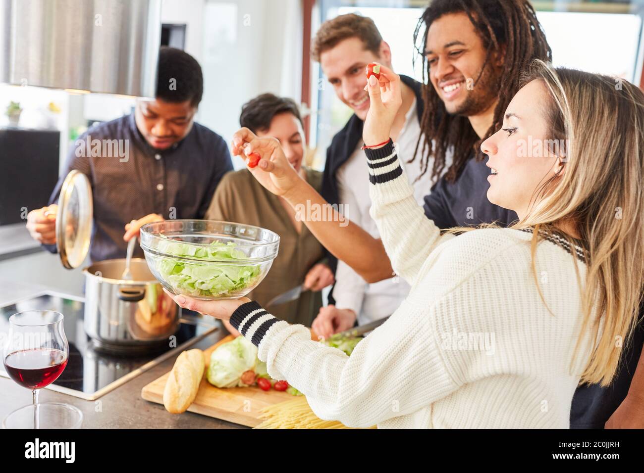 Dumme Gruppe von Studenten kochen und bereiten Salat in der Gemeinschaftsküche Stockfoto