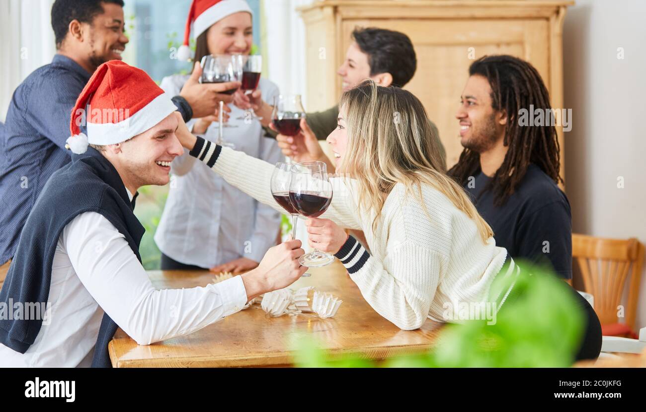 Zwei Kollegen flirten und klirrten vor Weihnachten auf einer Weihnachtsfeier im Büro Stockfoto