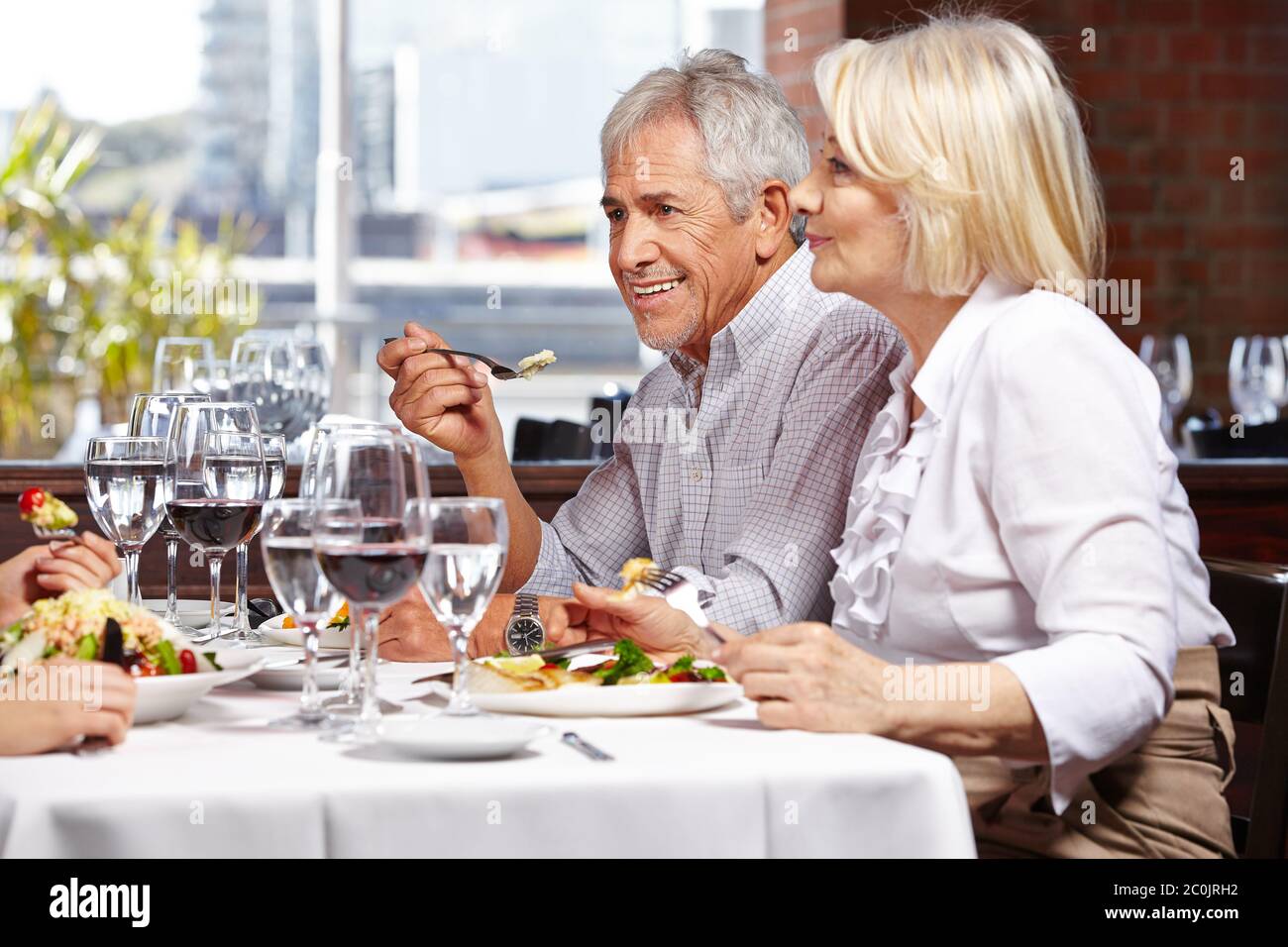 Familie geht mit zwei Senioren ins Restaurant Stockfoto