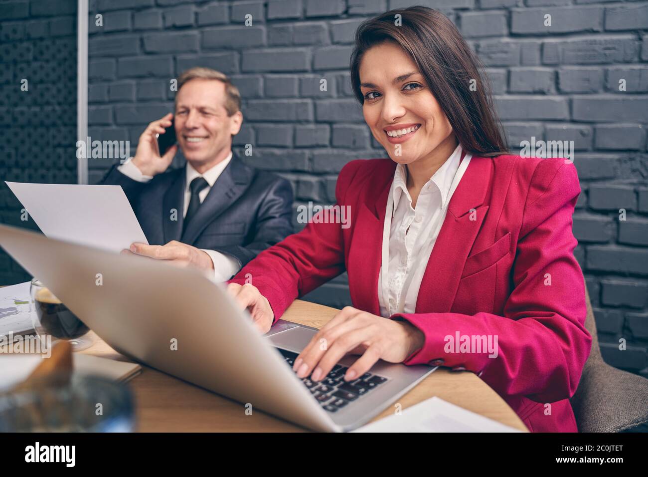 Attraktive junge Managerin, die ihre Finger auf der Tastatur hält Stockfoto