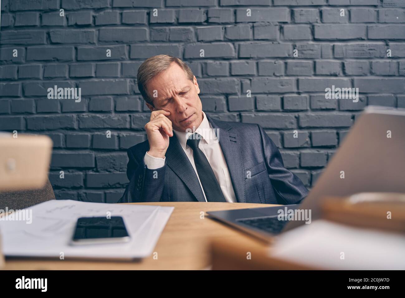 Gelangweilter Geschäftsmann schläft während eines Online-Meetings Stockfoto