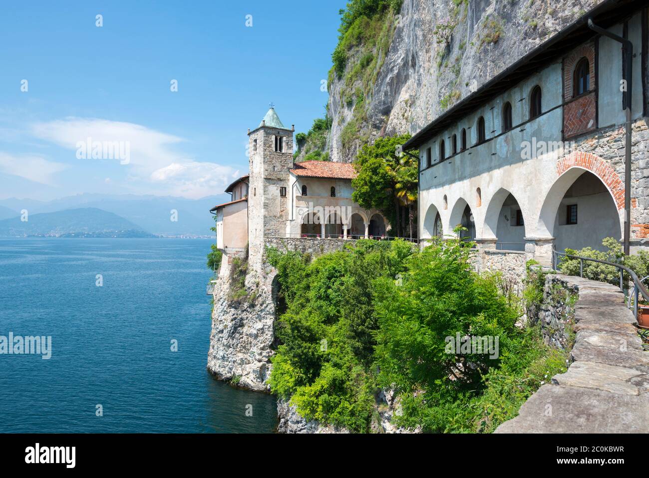 Eremo di Santa Caterina del Sasso und Alpine Lago Maggiore mit Berg in einem sonnigen Tag in der Lombardei, Italien. Stockfoto