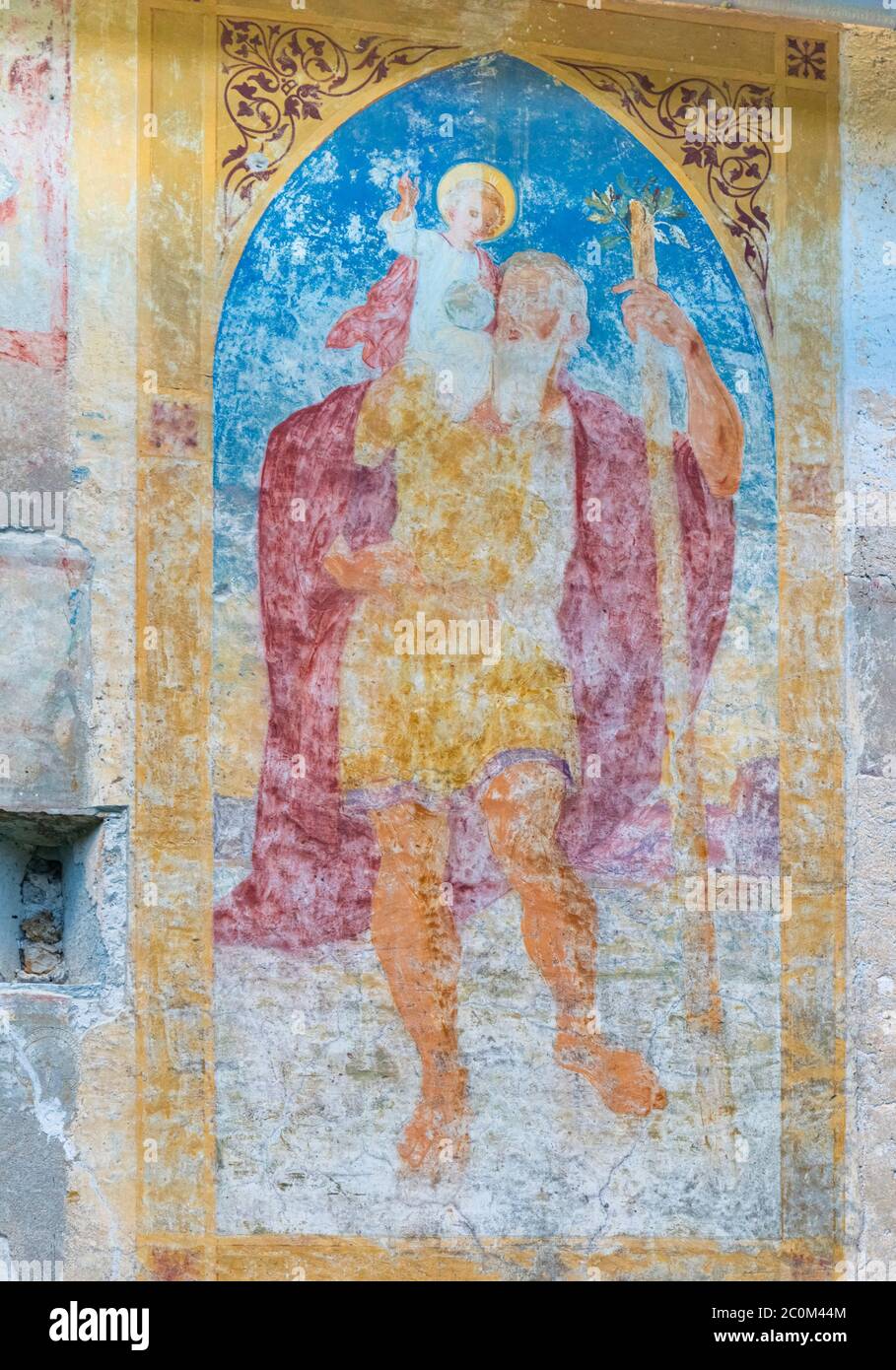 Fresko des Heiligen Christophorus an einer Außenwand der romanisch-gotischen Kirche des Heiligen Johannes des Täufers, die um 1100 am Ufer des Sees erbaut wurde Stockfoto
