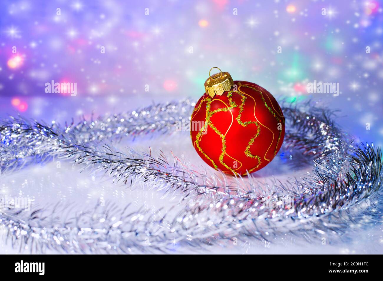 Roter Weihnachtsbaumball und Lametta. Weihnachtsdeko Stockfoto